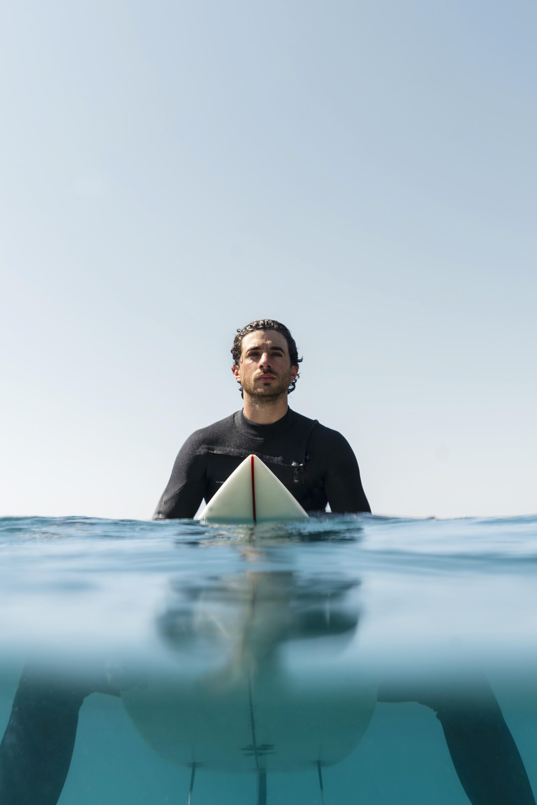 medium-shot-man-sitting-on-surfboard